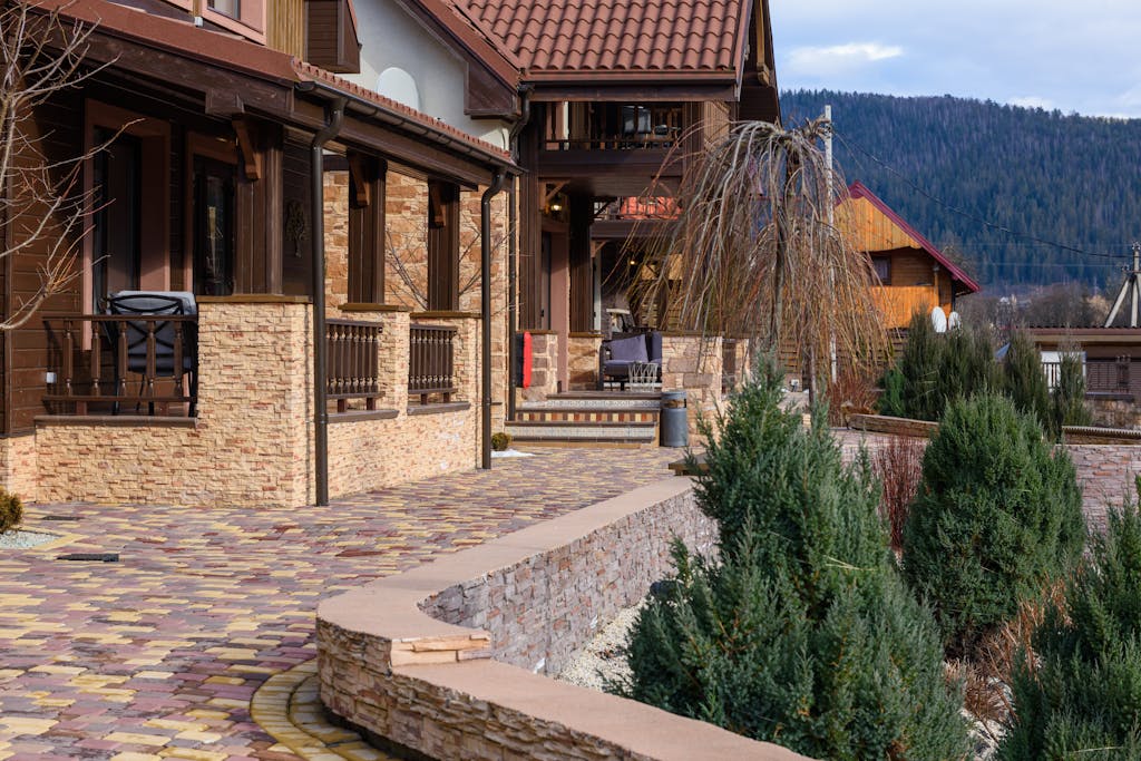 Beautiful rustic house exterior with landscaped walkway in a tranquil countryside setting.